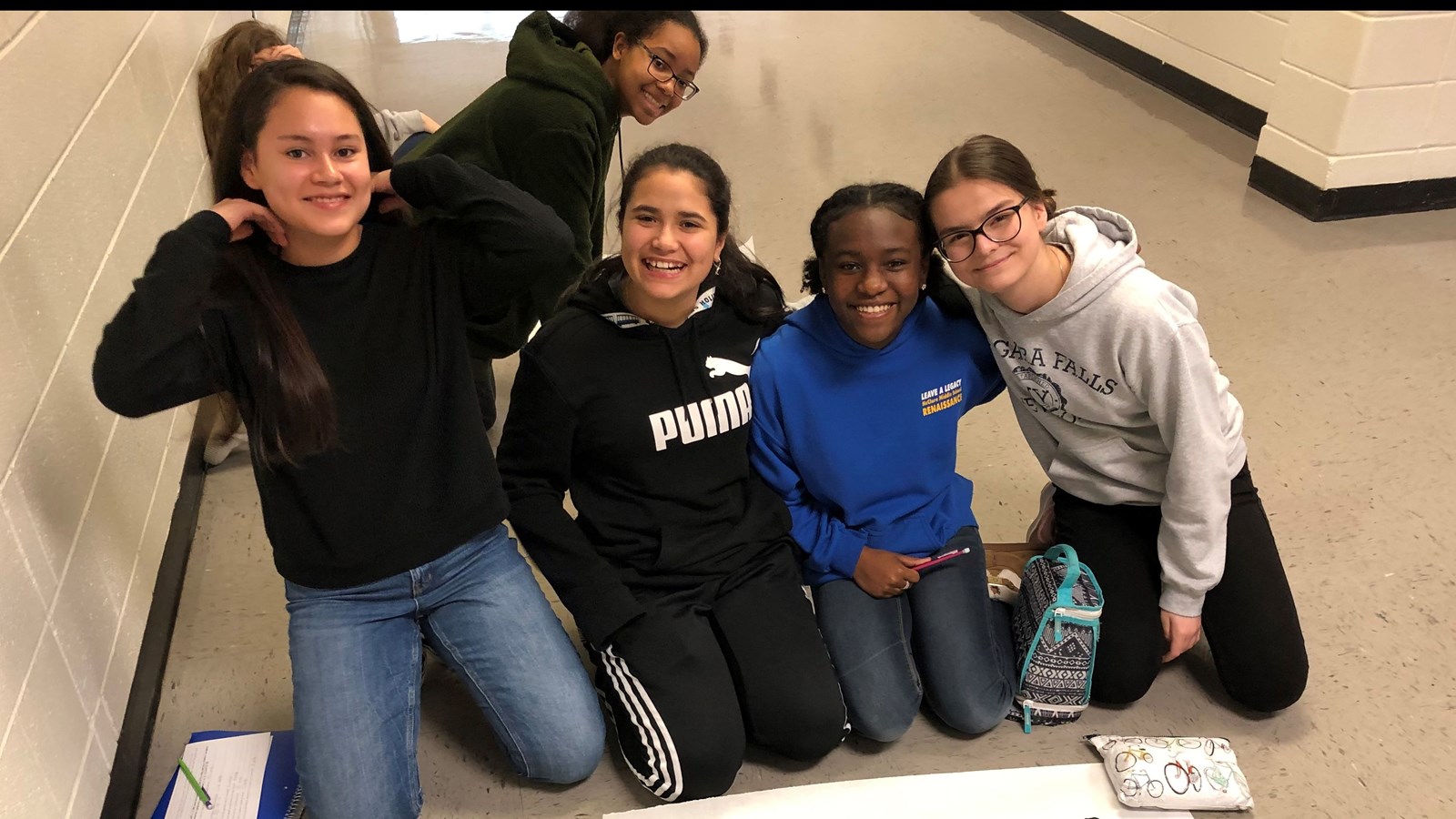 Students working on posters in the hall.