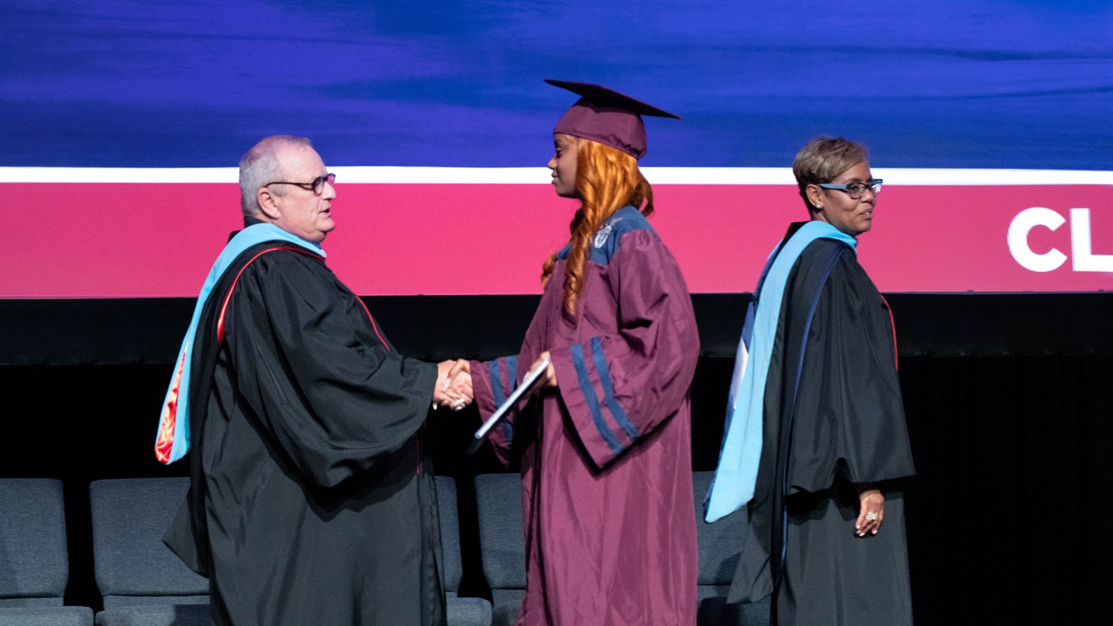 Cobb Schools Board ember Brad Wheeler congratulates a graduate at the Summer Commencement Ceremony