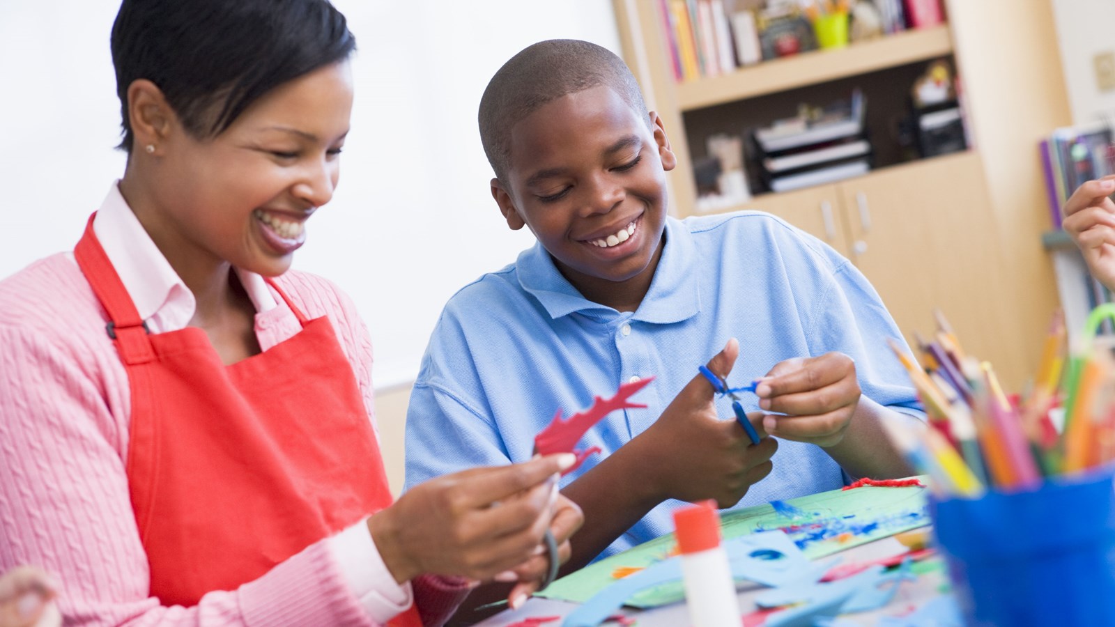 A teacher helps a student in art class